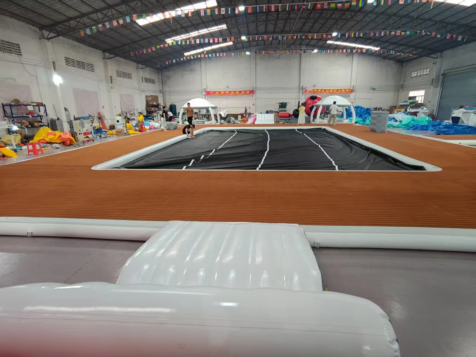 Wide workshop view with a large deck assembly and shaded platforms in the background