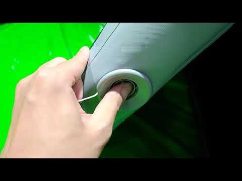 Close-up of a fitting on a grey inflatable section beside green material